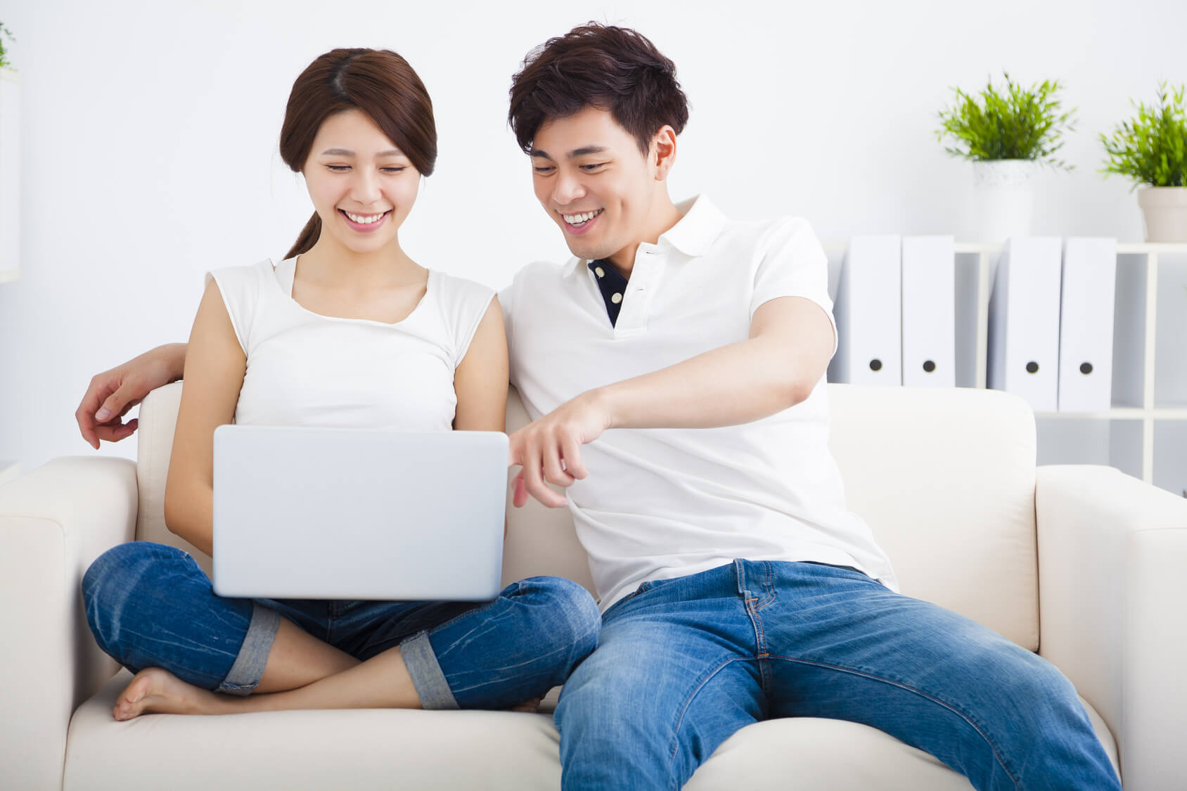 asian Couple on sofa with laptop computer