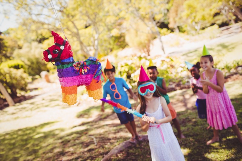 Little girl is going to broke the pinata for their birthday